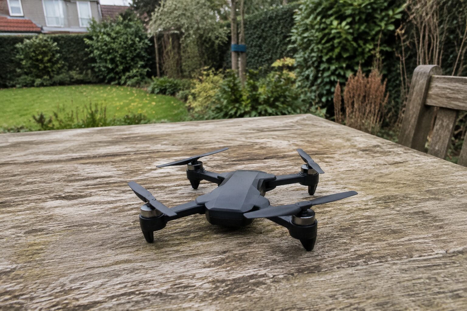 Een klein eenvoudig dronetje op een houten tuintafel