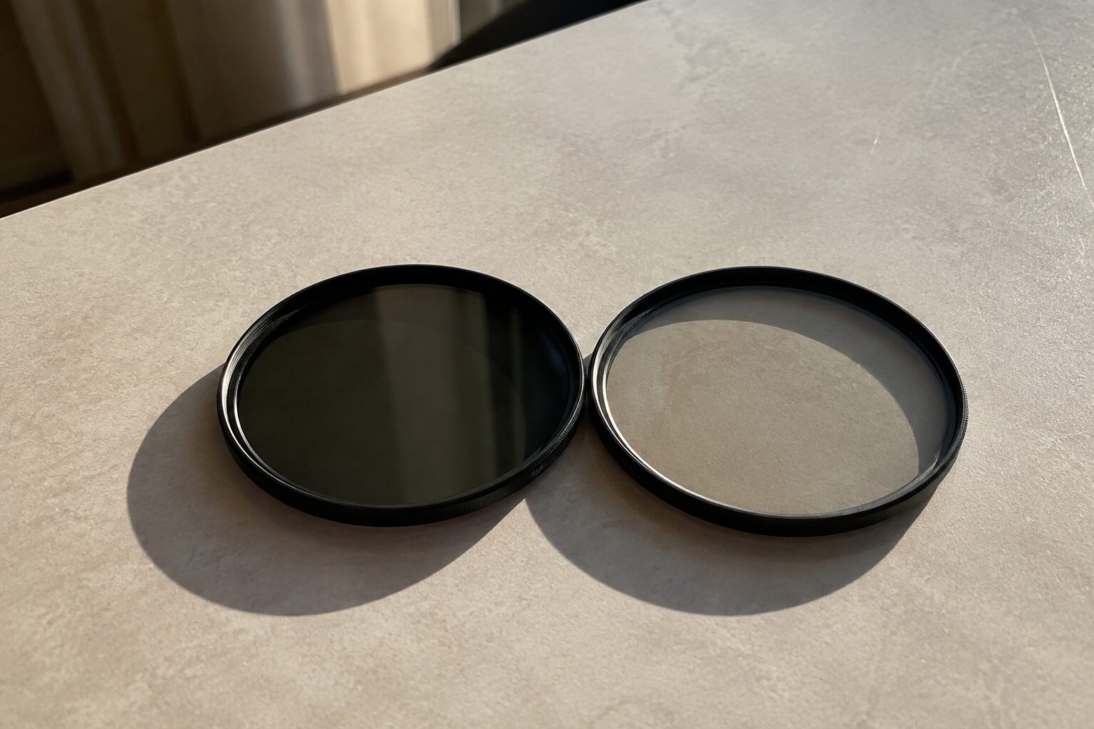 Twee ronde lensfilters naast elkaar op een lichte ondergrond